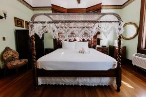a bedroom with a canopy bed with white sheets at Curry Mansion Inn in Key West