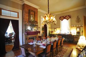 una sala da pranzo con tavolo, sedie e lampadario pendente di HH Whitney House - A Bed & Breakfast on the Historic Esplanade a New Orleans