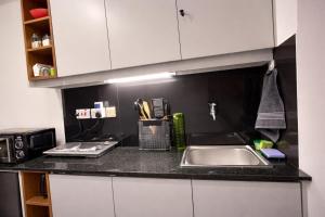 a kitchen counter with a sink and a microwave at The Cozy Cube at Tsavo Sunset in Nairobi +3 photos