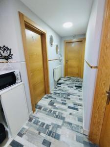a hallway with a tile floor in a room at Coalla Rooms Luxe in Lugones