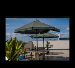 two tables and chairs under an umbrella on a patio at The Cozy Cube at Tsavo Sunset in Nairobi