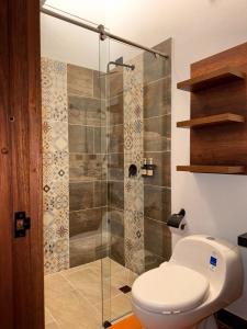 a bathroom with a toilet and a glass shower at Hotel Cala in Cucaita +50 photos