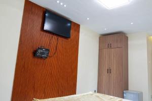 a bedroom with a flat screen tv on a wall at Résidence Madior C1 in Dakar
