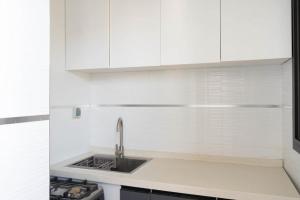 a kitchen with white cabinets and a sink at Résidence Madior C1 in Dakar