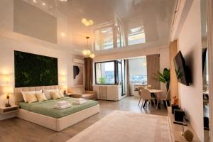 a bedroom with a large bed and a living room at Building Stefan Resort 2 Mamaia Nord - Studio 804 in Năvodari