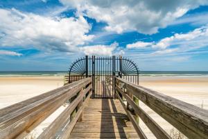 a gate on a wooden boardwalk to the beach at St Augustine Beachfront Condo with Ocean Views in Saint Augustine Beach