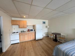 a kitchen with a refrigerator and a table in a room at Seabreeze Motel in Old Orchard Beach