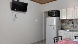 a kitchen with a white refrigerator and a table with chairs at Iguazú Home & Relax in Puerto Iguazú +8 photos