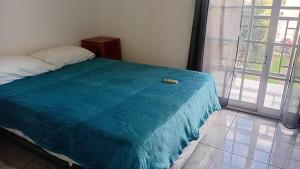 a bedroom with a bed with a blue blanket on it at Iguazú Home & Relax in Puerto Iguazú