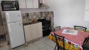 a kitchen with a table and a white refrigerator at Iguazú Home & Relax in Puerto Iguazú