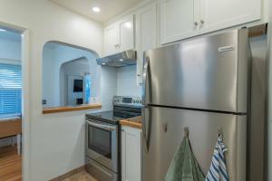 a kitchen with a stainless steel refrigerator and white cabinets at Park Street Pad in Paso Robles +19 photos