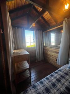 a bedroom with a bed and a window in a room at Chalé Rosa dos Ventos in Itapoa