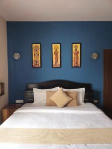 a bedroom with a blue wall with a bed at Kalon Elpis Villa in Ooty