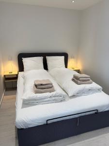 a bed with white sheets and towels on it at Private apartment with panoramic ocean views in Ilulissat