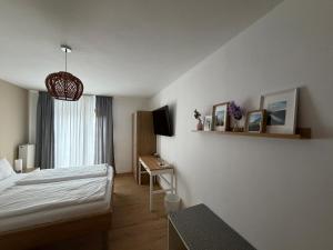 a bedroom with a bed and a desk with a television at Ley Hotel in Klotten