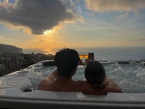 a man and a woman sitting in a hot tub with glasses of wine at Corte Degli Ulivi Resort in Vico Equense