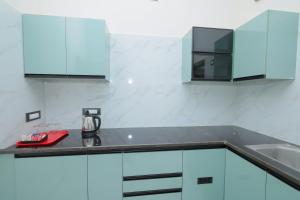a kitchen with blue cabinets and a counter top at MK service apartment in Tirunelveli +14 photos