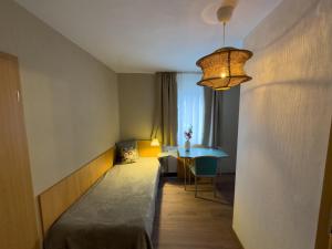 a room with a bed and a table and a chandelier at Ley Hotel in Klotten