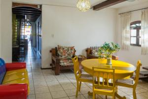 ein Esszimmer mit einem gelben Tisch und Stühlen in der Unterkunft Pousada Brisa do Mar in Porto Seguro