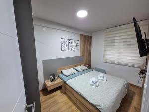 a small bedroom with a bed and a window at Centar Park Lux in Vrnjačka Banja +8 photos
