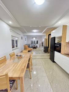a kitchen and living room with a wooden table and chairs at AS Holiday Home in Ljubuški