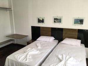 two beds sitting next to each other in a room at Confortavel Apartamento na Rua das Flores in Curitiba