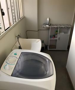 a small bathroom with a white toilet and a window at Confortavel Apartamento na Rua das Flores in Curitiba +43 photos