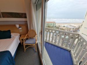 una camera da letto con balcone con vista sulla spiaggia di City Hotel a Senigallia Altre 89 foto