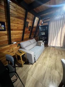 a living room with a white couch and a table at Chalé Rosa dos Ventos in Itapoa