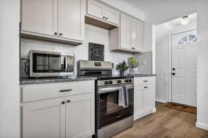 a kitchen with white cabinets and a stove and microwave at 113 Madison Ave, Cuyahoga Falls in Cuyahoga Falls