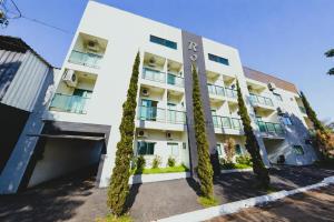 an apartment building with trees in front of it at Hotel Royal - Rubiataba in Rubiataba