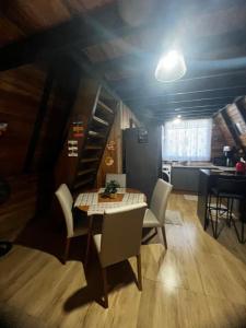 a dining room with a table and chairs and a kitchen at Chalé Rosa dos Ventos in Itapoa