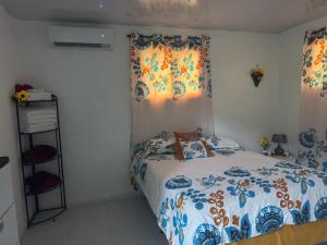a bedroom with a bed with a blue and white comforter at Rancho Doña Rita in Higuey