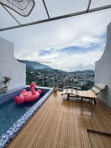 a balcony with a pool with pink inflatable flamingos on it at Kizuna villa in Diyeng
