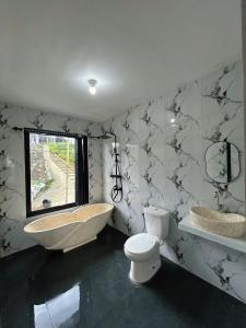 a bathroom with a sink and a tub and a toilet at Kizuna villa in Diyeng +19 photos