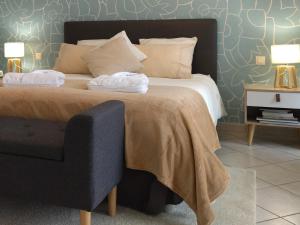 a bedroom with a large bed and a chair at Fleurs de Cosmos, suite lumineuse climatisée in Albi