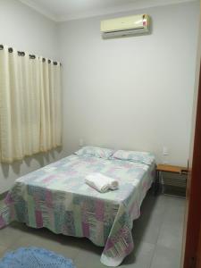 a bedroom with a bed with two towels on it at Recanto Três Rios in Santa Clara dʼOeste
