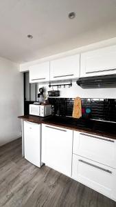 a kitchen with white cabinets and a counter top at Appartement T1bis Saint Herblain in Saint-Herblain