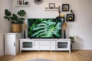 a living room with a flat screen tv on a white cabinet at Sunny Nest 1 in Vaasa