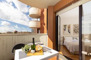 a room with a bed and a table with a bottle of wine at Milano Lux Apartament - Private Indoor Parking in Sesto San Giovanni