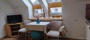 a dining room with a table with chairs and a tv at Apartment Bertík in Třeboň