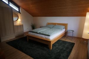 a bedroom with a bed and a table and a lamp at Ferienwohnung EGS in Lahr