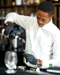 a man in a kitchen pouring a drink into a cup at KÓLÒ Hôtel in Yaoundé +60 photos