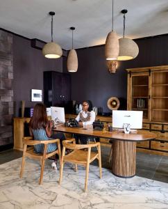 two women sitting at a table with their laptops at KÓLÒ Hôtel in Yaoundé
