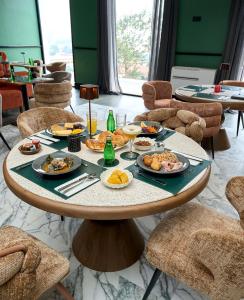 a table with plates of food on it in a restaurant at KÓLÒ Hôtel in Yaoundé