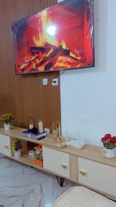 a tv on top of a table with a fireplace at Résidence Eden2 in San-Pédro