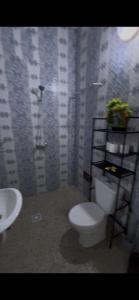 a bathroom with a toilet and a sink at Résidence Eden2 in San-Pédro +4 photos