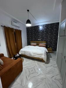 a bedroom with a bed and a couch at Résidence Eden2 in San-Pédro