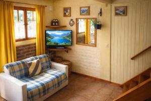 a living room with a couch and a television at Cabaña LOW COST in El Bolsón