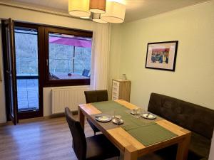a dining room with a table and chairs and a window at Ferienwohnung Moselblick in Ediger-Eller